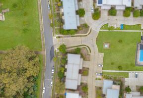 Aerial over Bayside Vista showing the pool and parkland